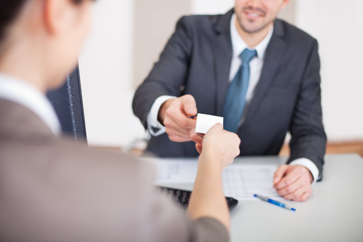 Candidate giving business card to employer